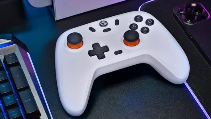 White budget gaming controllers for PC on desk setup with RGB keyboard