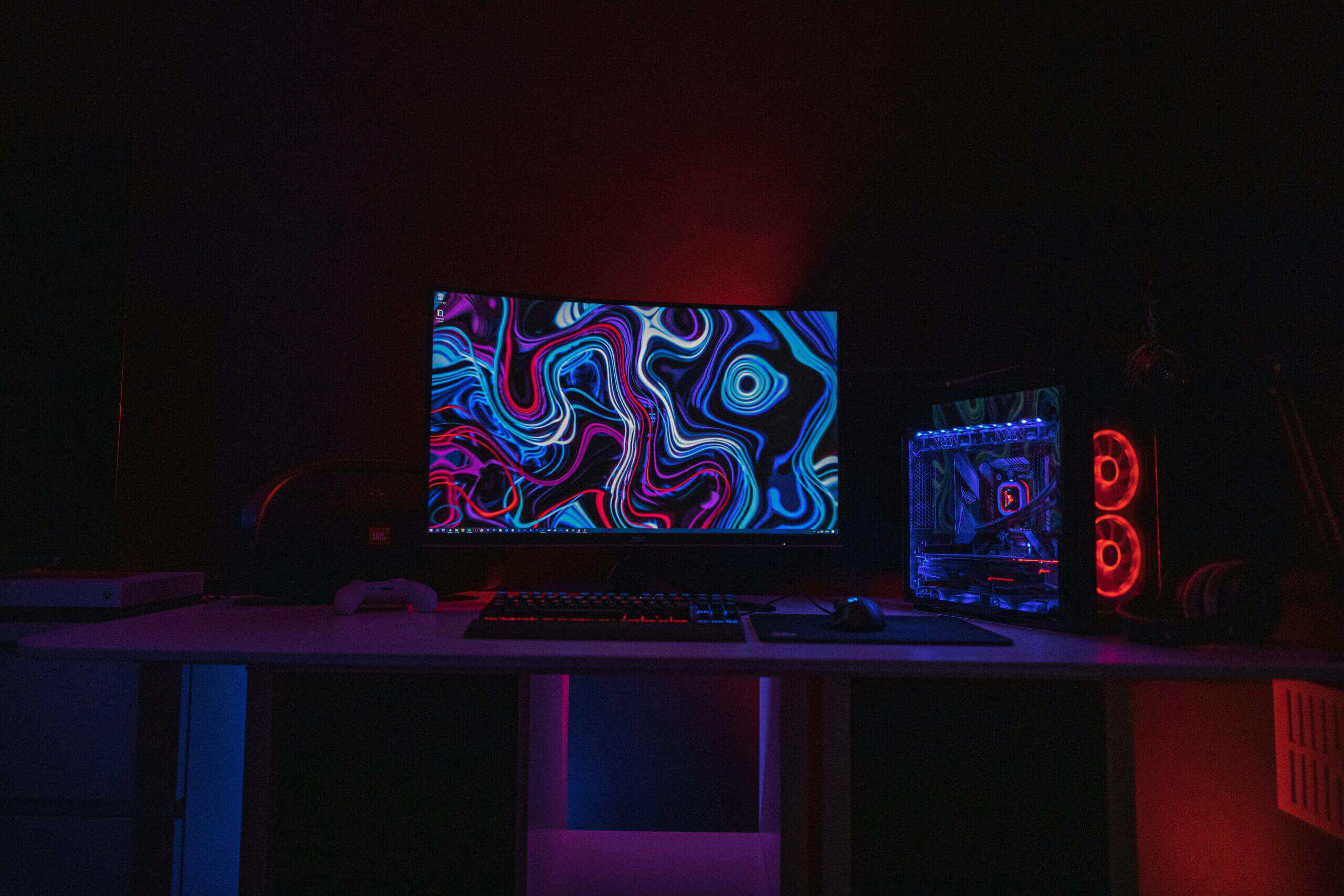 1080p vs. 4K gaming PC setup with monitor, RGB tower with red fans, mechanical keyboard, and blue ambient lighting