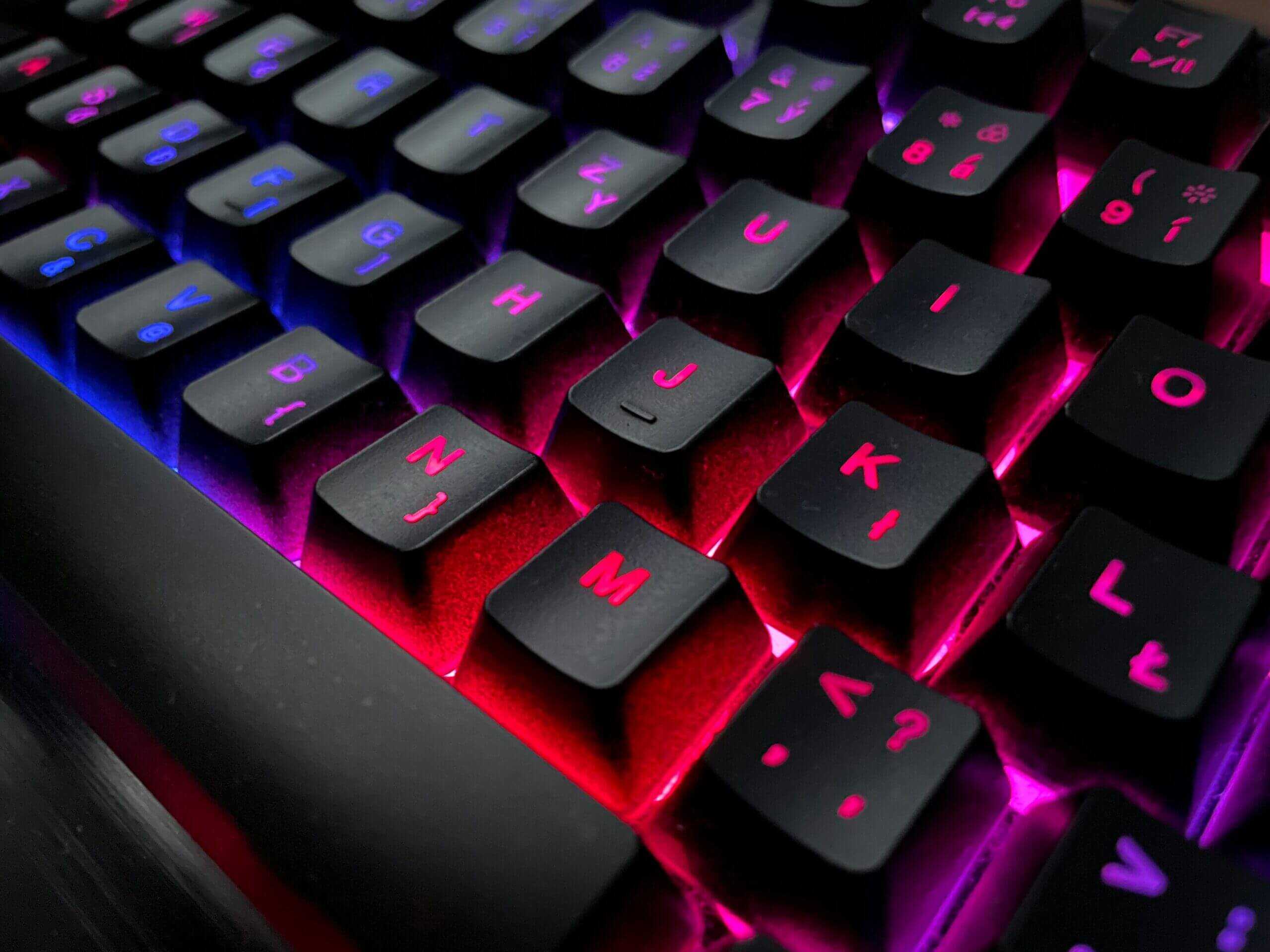 RGB mechanical keyboard with red and purple lighting on black keycaps