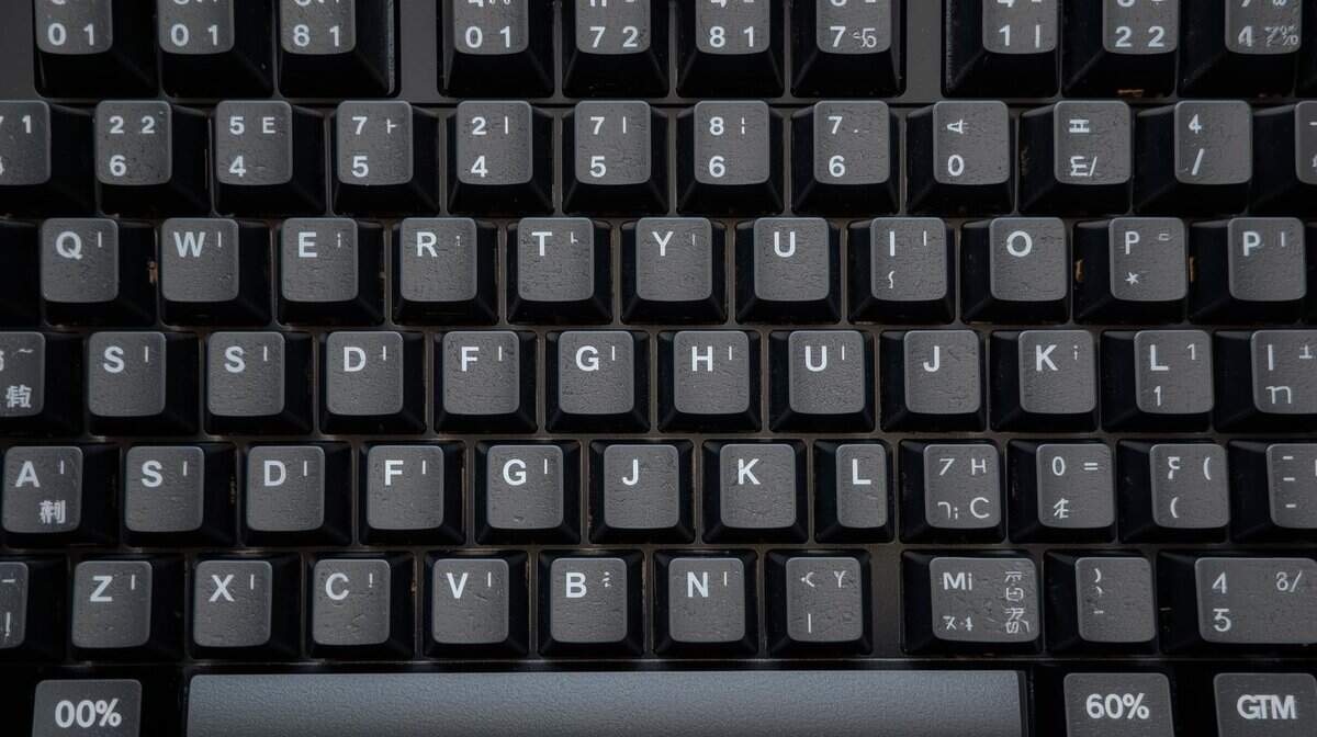 A 60% keyboard layout with black keycaps showing the compact design without function row or arrow keys.