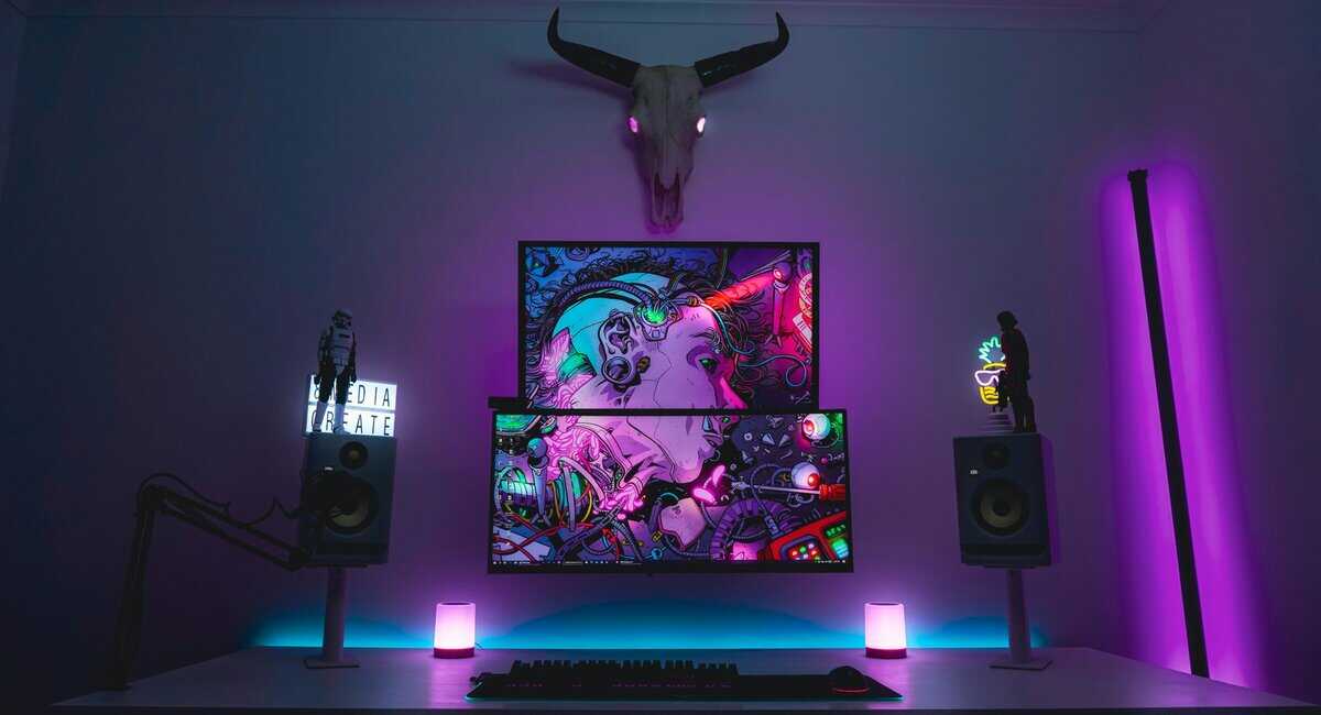 21:9 vs 16:9 stacked dual monitor streaming setup with studio speakers and purple RGB ambient lighting