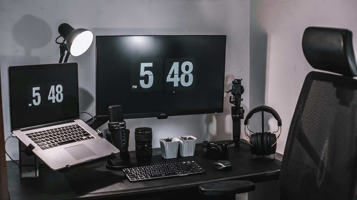 Minimalist content creator desk showing how to start streaming on Twitch with laptop, external monitor, USB microphone, Sony camera, headphones, and ergonomic chair
