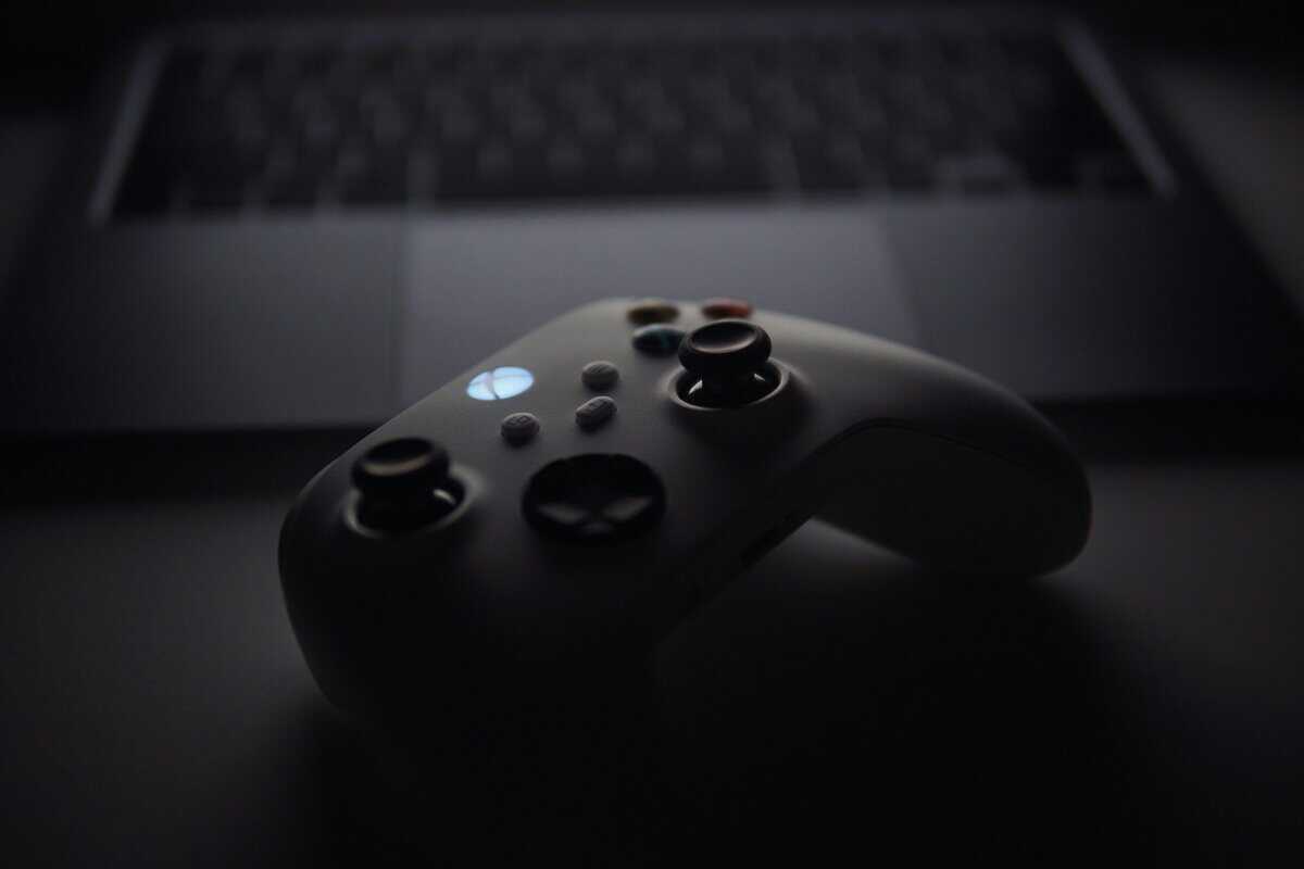 Best Xbox controller standard Xbox Wireless Controller in front of laptop keyboard with glowing Xbox button