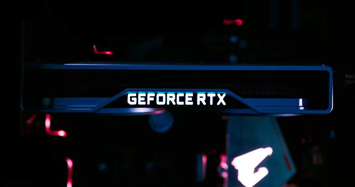 Nvidia GeForce RTX graphics card with illuminated logo and Gigabyte Aorus branding glowing in a dark PC case with blue and red ambient lighting — a premium option when choosing the best budget graphics card.