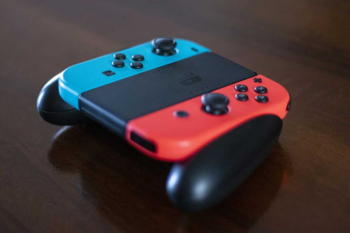 Nintendo Switch controller Joy-Cons in neon blue and red attached to grip