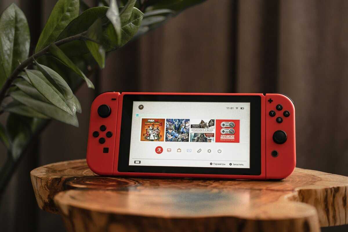 Best capture card for Nintendo Switch with red Joy-Con controllers showing home screen on wooden stand