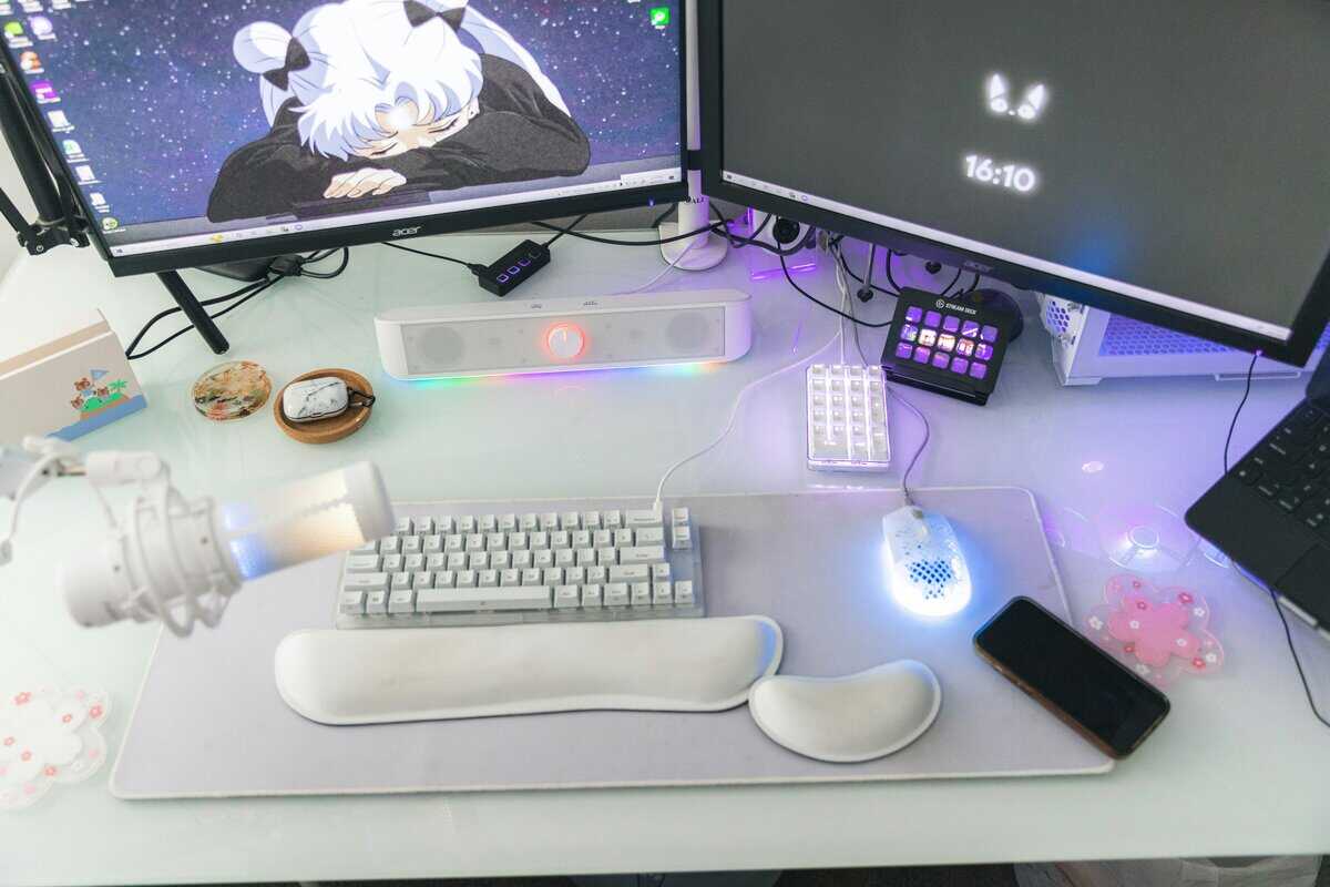 Gaming and streaming desk setup showing a foam wrist rest for a keyboard and mouse alongside a compact keyboard and stream deck
