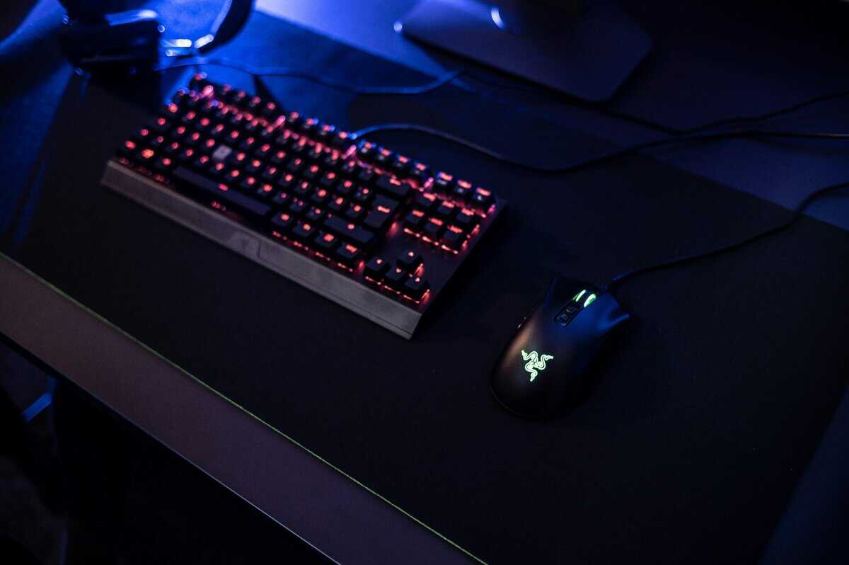 Gaming keyboard and mouse combo with red backlighting and Razer mouse on a dark desk mat