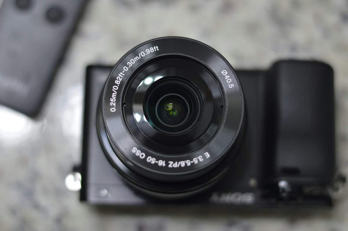 Close-up of a Sony mirrorless camera with 16-50mm lens showing sensor and aperture details for a 4K ultra HD camera