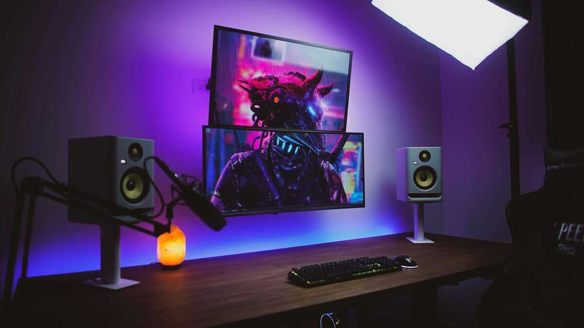 Dual-monitor streaming desk setup with purple backlighting, studio speakers, and boom mic, the kind of setup where choosing 144hz vs 240hz matters