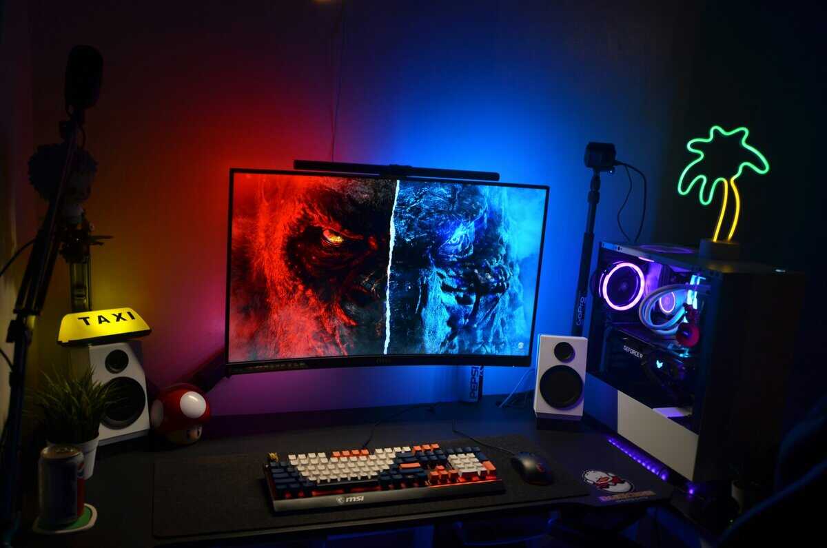 Colorful gaming setup with curved monitor, RGB PC case, and mechanical keyboard, a setup that could run either a 144hz vs 240hz display