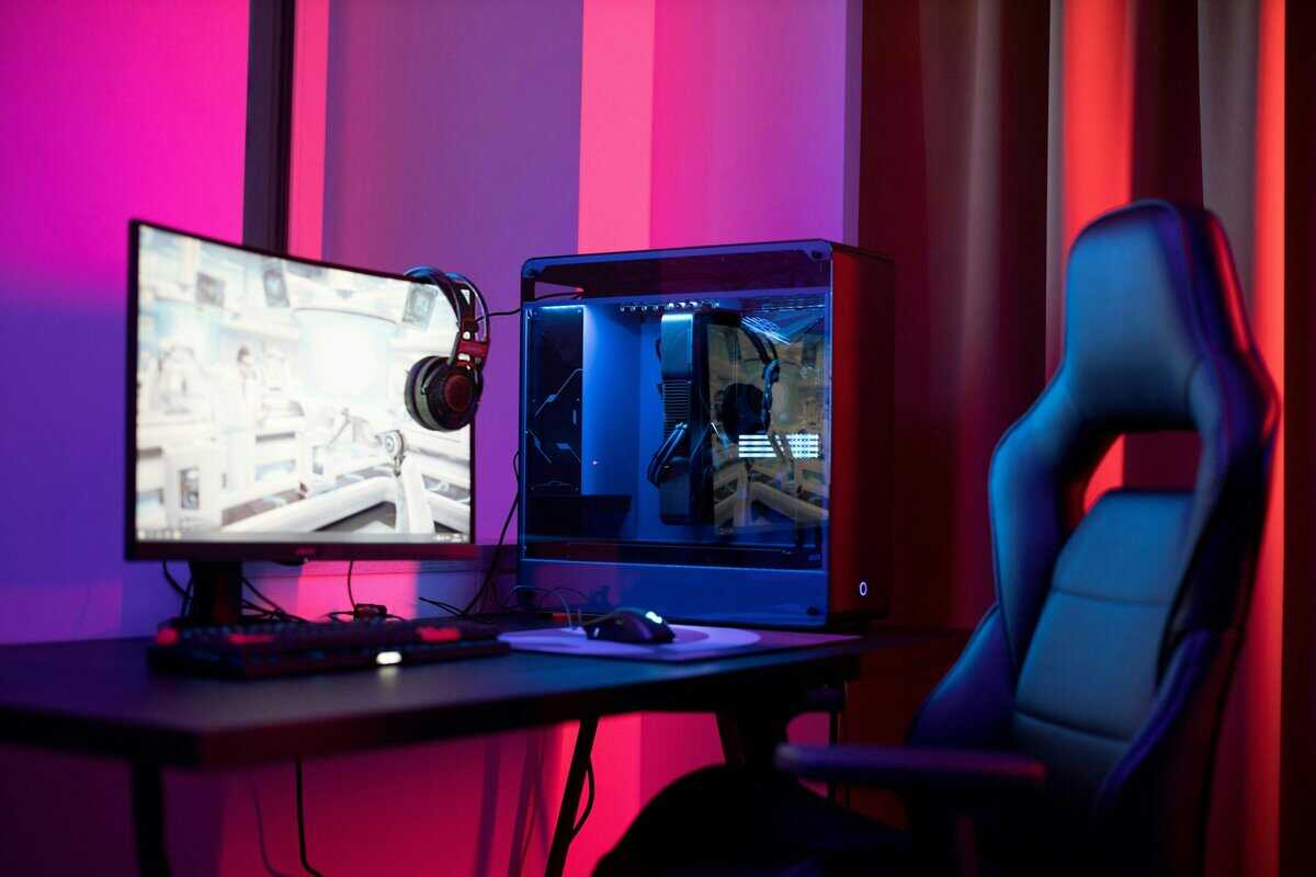 Gaming chair next to a PC tower and monitor with pink and blue RGB lighting, the kind of setup built around the best budget gaming chair