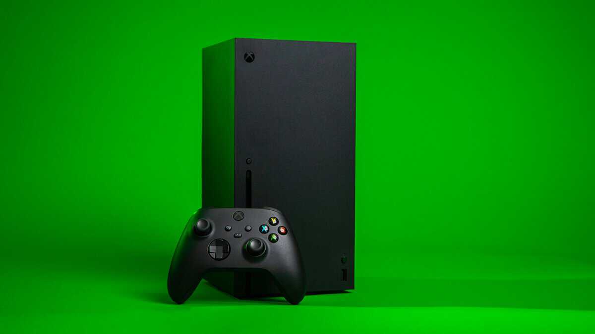 Xbox Series X console standing tall on a green background with a black Xbox Wireless Controller in front, the centerpiece every best Xbox Series X accessories build is built around