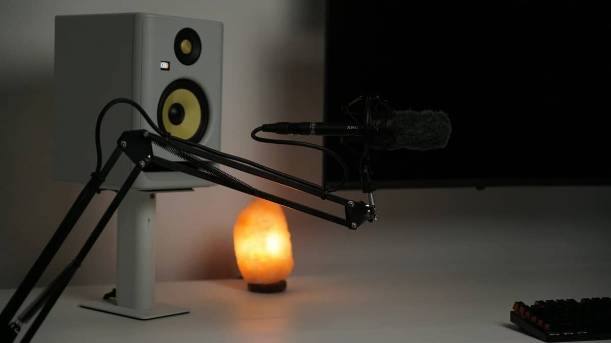 Spring-tensioned boom arm holding a shotgun microphone on a desk, showing the versatility of the best microphone boom arm for content creators