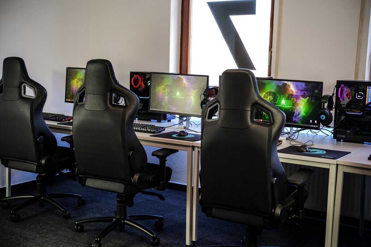 Row of black gaming chairs at desks in an esports lab, demonstrating durability of the best budget gaming chair across heavy use