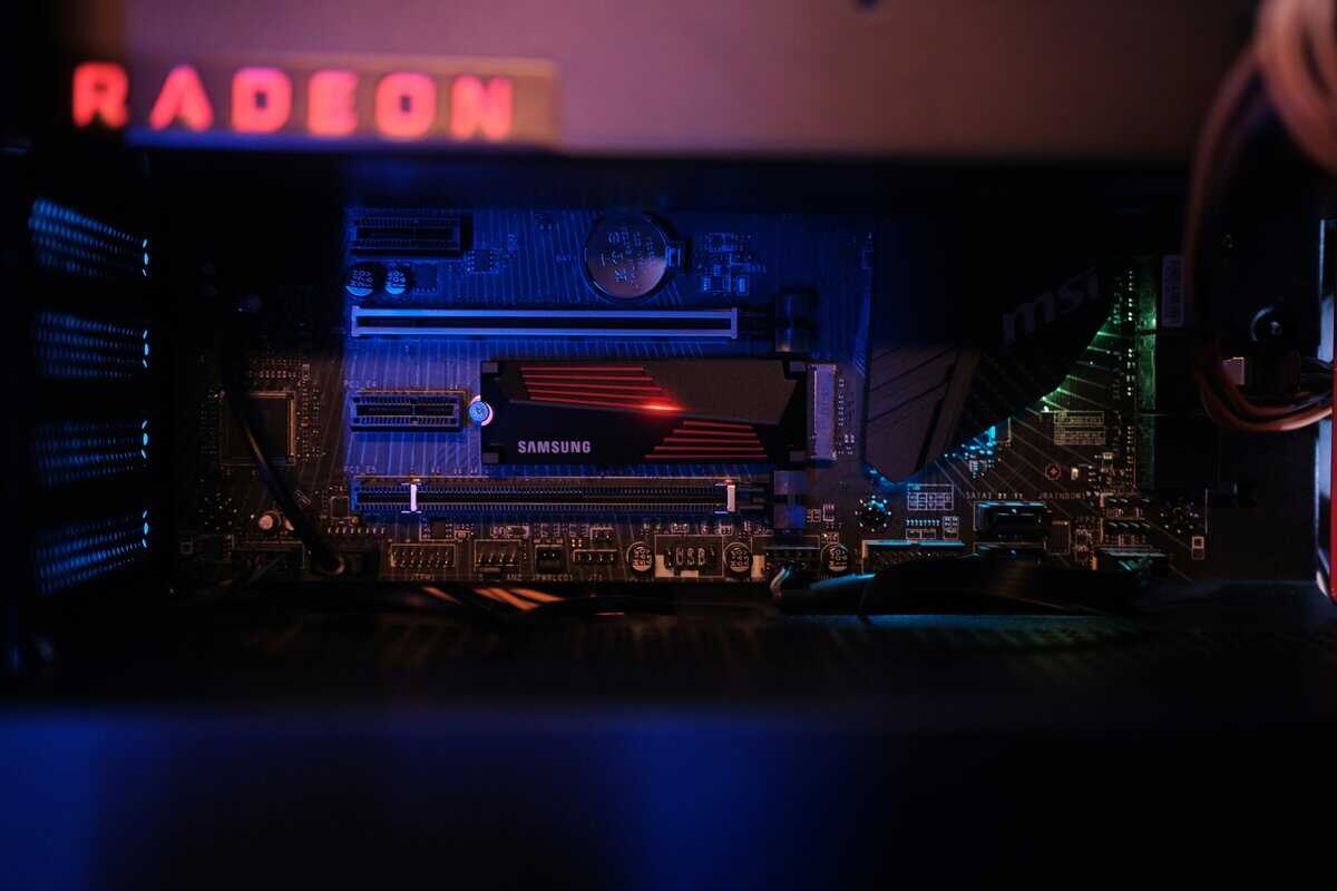 Samsung NVMe SSD installed on a gaming PC motherboard next to a Radeon GPU, illustrating the ssd vs hdd for gaming upgrade