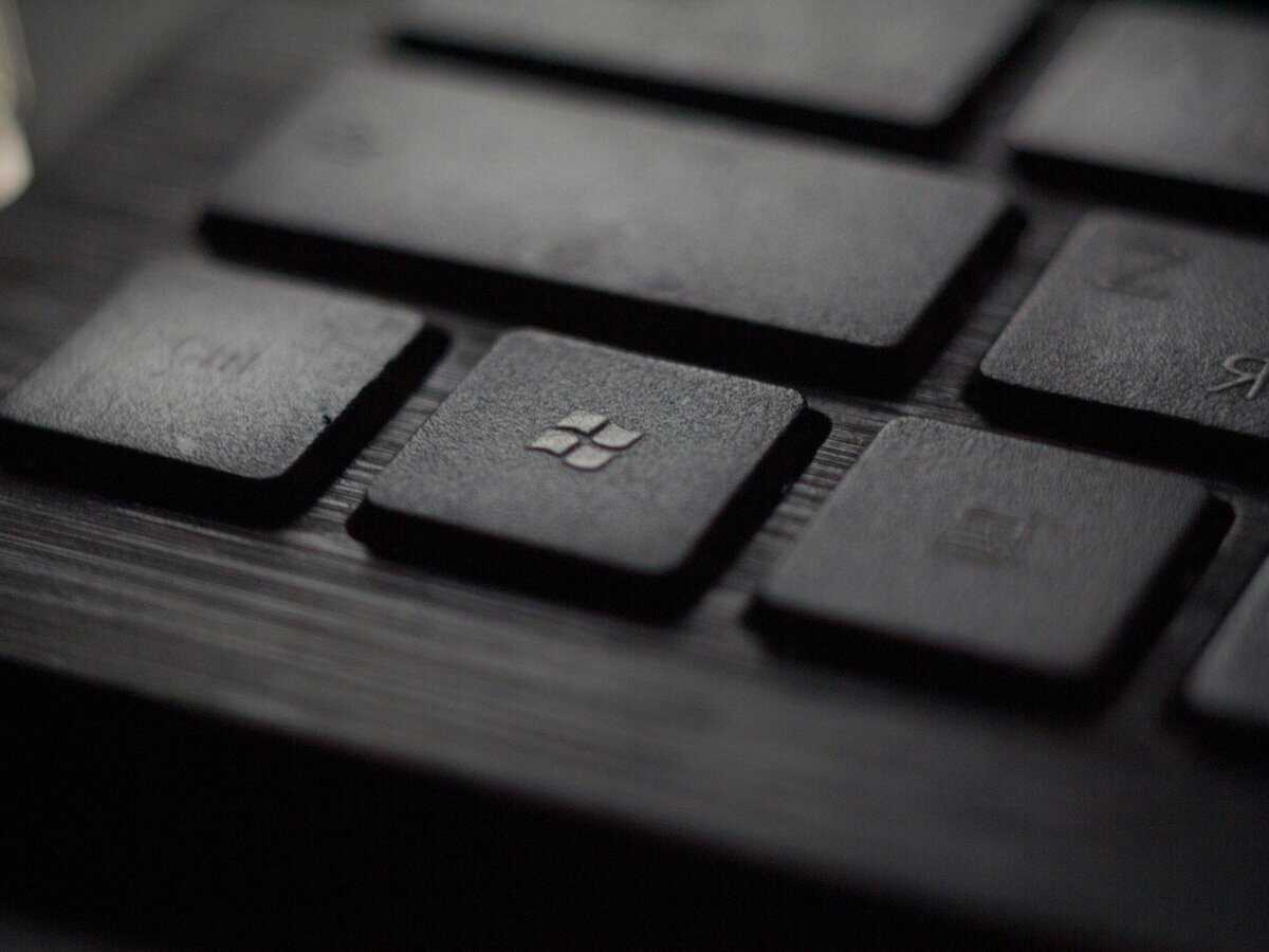 Close-up of the Windows key on a dark keyboard, representing the core question of Windows 11 Home vs Pro for gaming