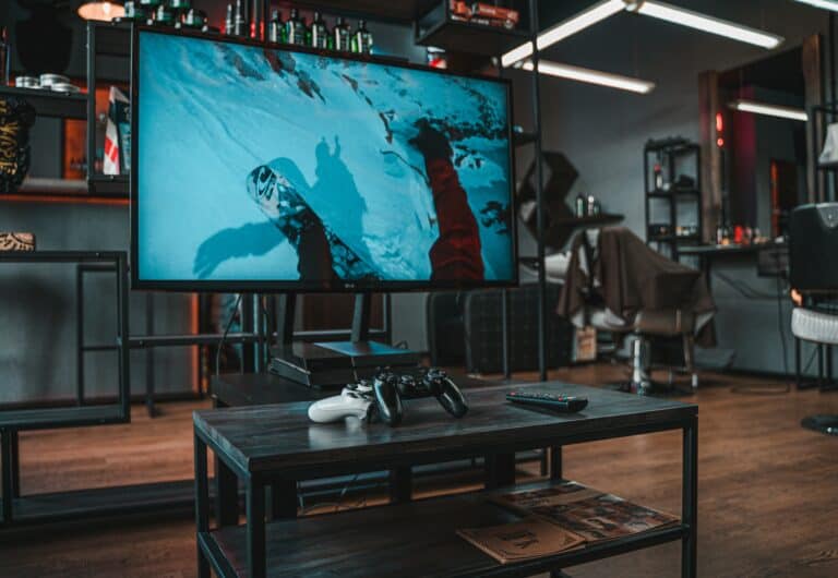 Living room TV gaming setup with consoles and controllers, the TV side of the gaming monitor vs TV comparison