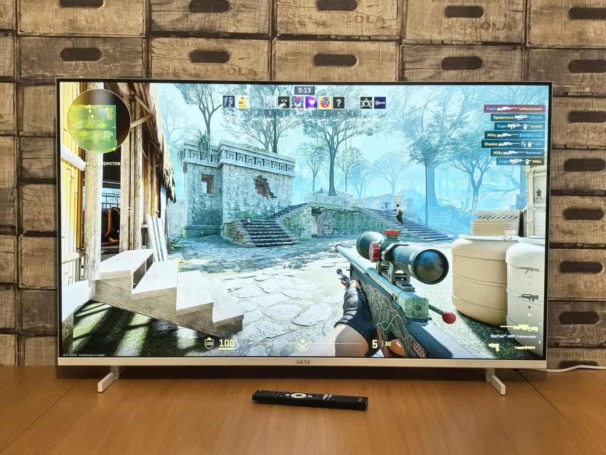 Large 4K TV displaying an FPS game from a couch distance, a real-world test of gaming monitor vs TV for fast-paced titles