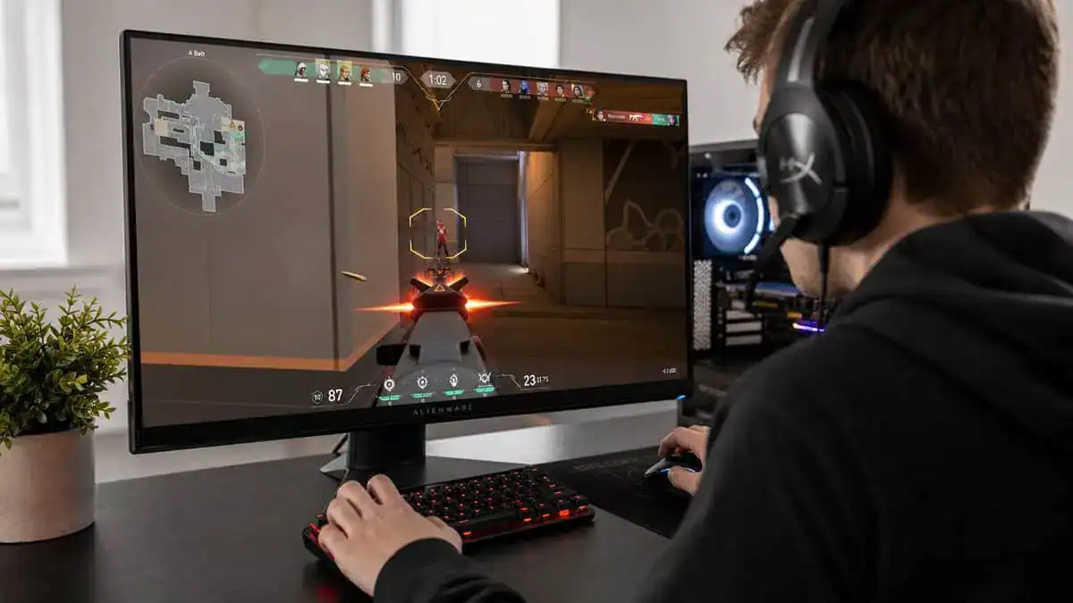A gamer in a headset playing a first-person shooter on a monitor, the kind of fast game where 60Hz vs 144Hz matters most