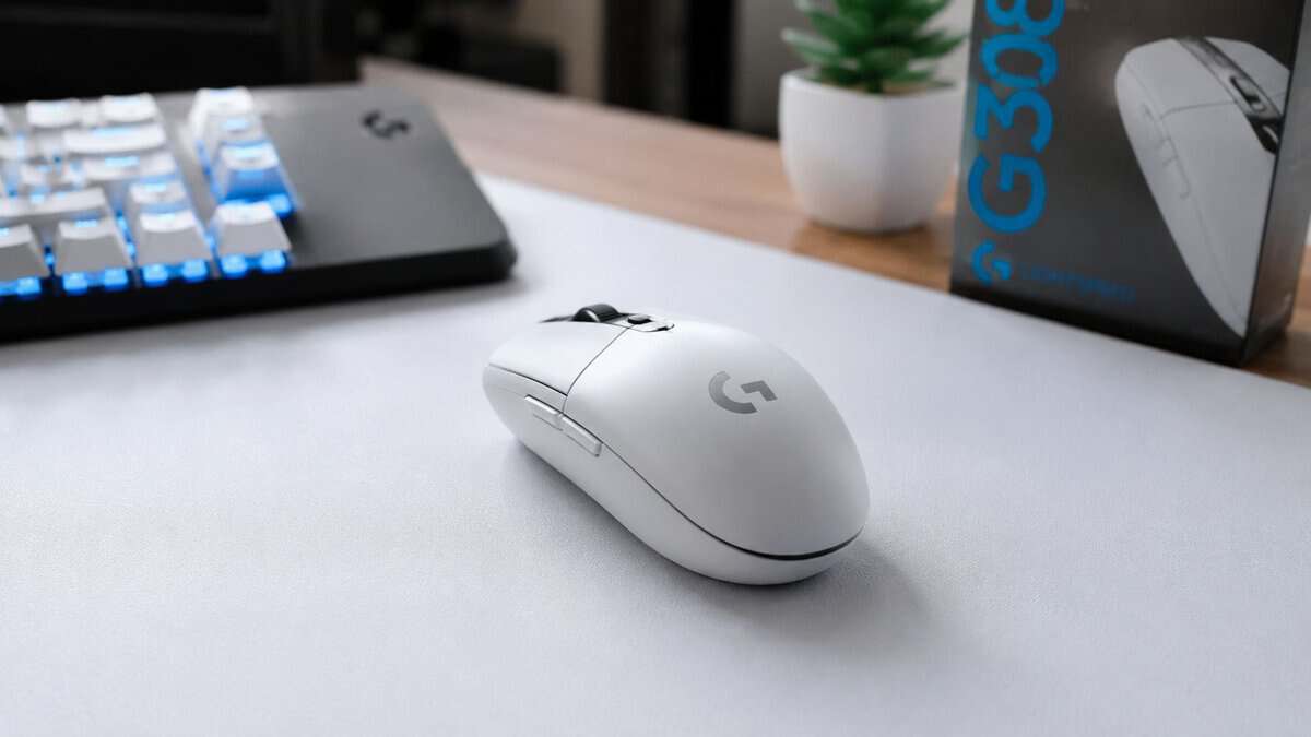 White Logitech G305 wireless gaming mouse on a desk beside its retail box and an RGB keyboard, a strong-value choice for the best mouse for Tarkov