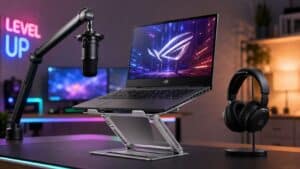 Gaming laptop raised on an adjustable aluminum stand between a boom-arm microphone and a headset, showing how the best laptop stand anchors a streaming desk