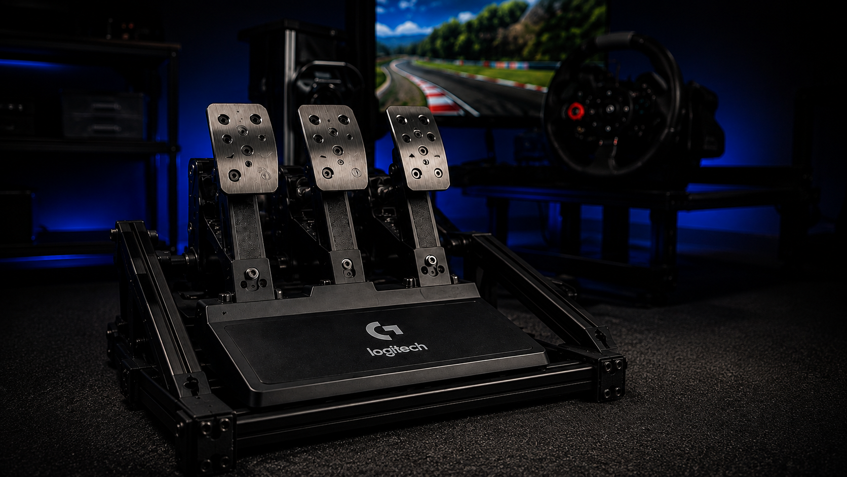 A Logitech G three-pedal set bolted to an aluminium rig frame, the rigid mounting that lets the best sim racing pedals deliver repeatable braking
