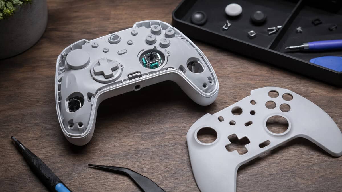 Disassembled white controller with the faceplate removed and analog stick module exposed, the internals that decide the best hall effect controller