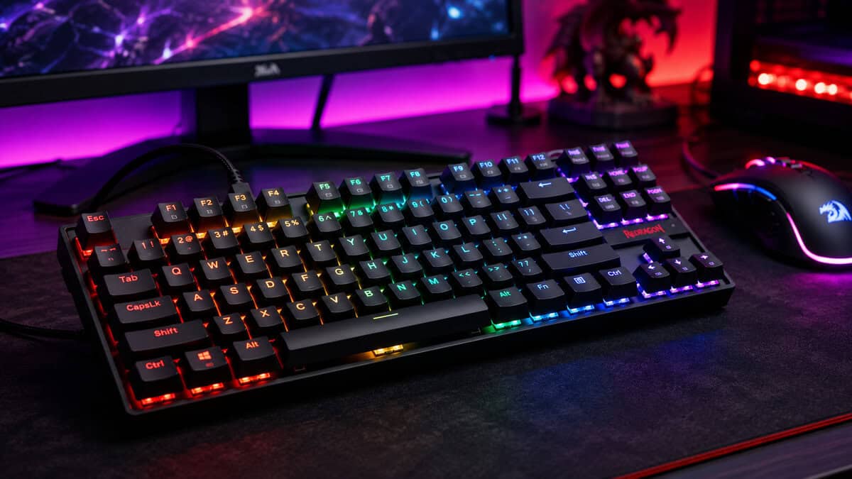 Redragon K552 tenkeyless lit in rainbow RGB beside a matching Redragon mouse, a budget answer to what is N key rollover on a gaming desk