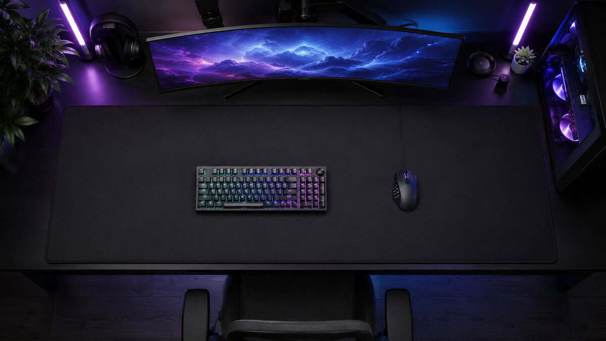 Full desk covered by an XXL cloth pad hosting a keyboard and 12-button mouse, the size argument for the best MMO mousepad