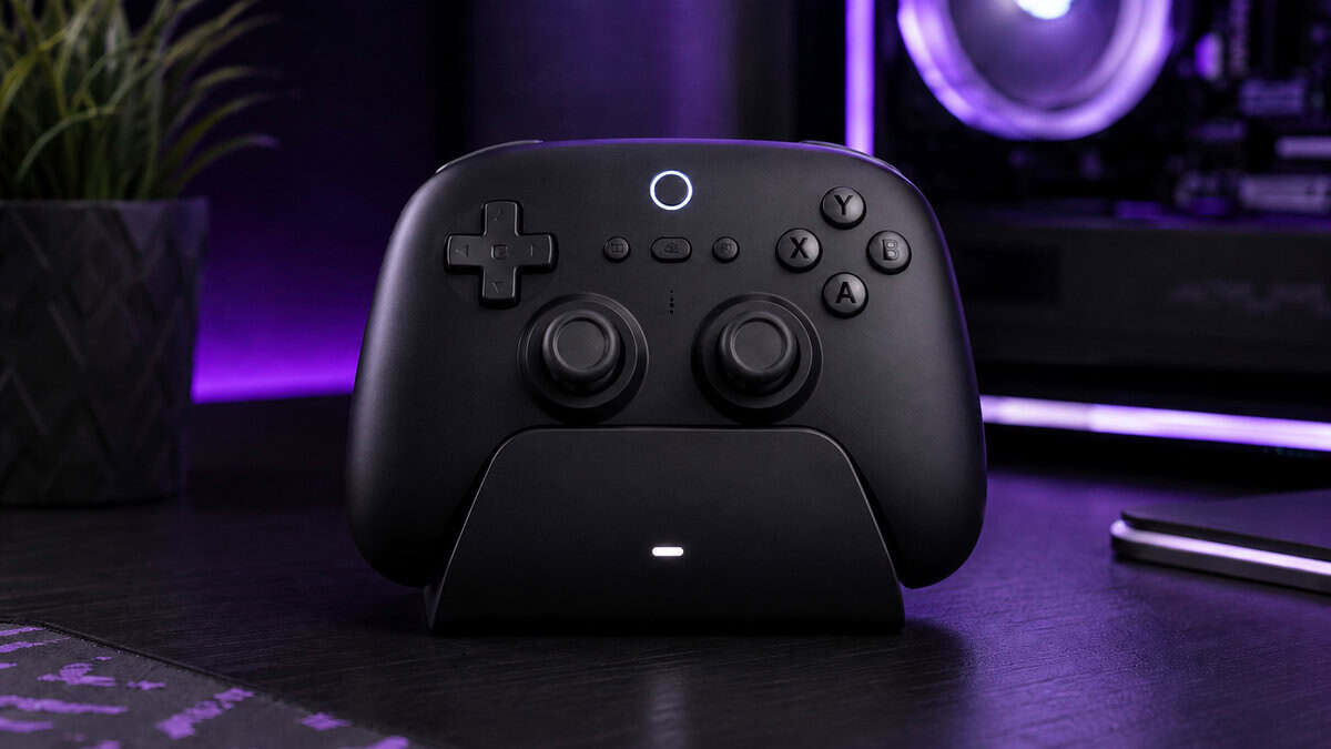 Black wireless controller charging in its dock beside a glowing gaming PC, where the tmr vs hall effect battery advantage earns its keep