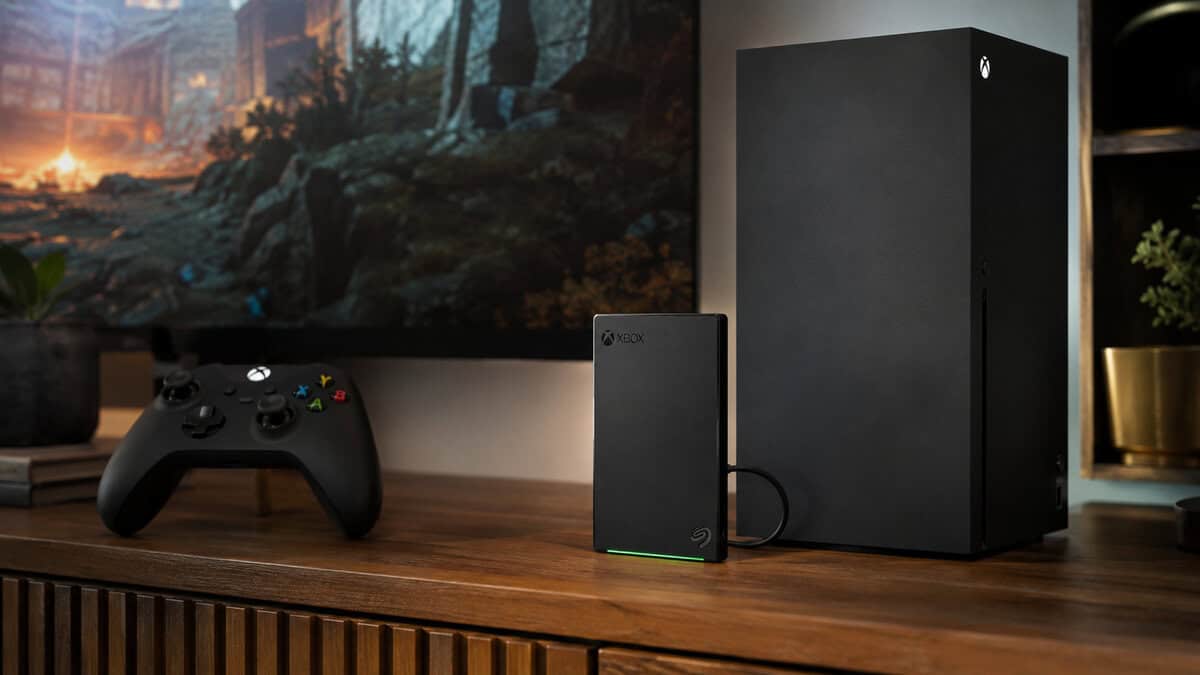Xbox-branded external drive with a green LED strip standing beside an Xbox Series X console and controller, the capacity-first answer when shopping for the best external SSD for Xbox Series X