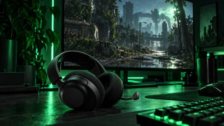 The best headset for Arc Raiders, a black SteelSeries Arctis Nova 5 Wireless with its boom mic out, on a green-lit desk facing a ruined city and a giant ARC machine on the monitor