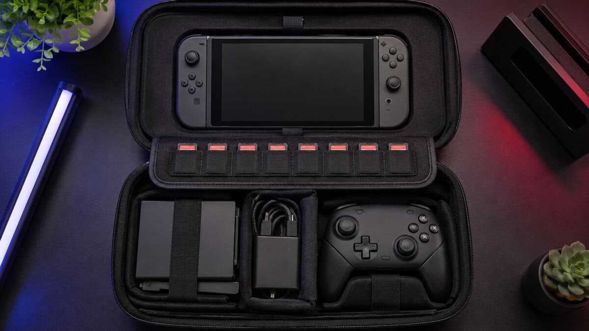 Overhead view of a deluxe switch 2 case packed with the console, eight game cards, a controller, and charging gear