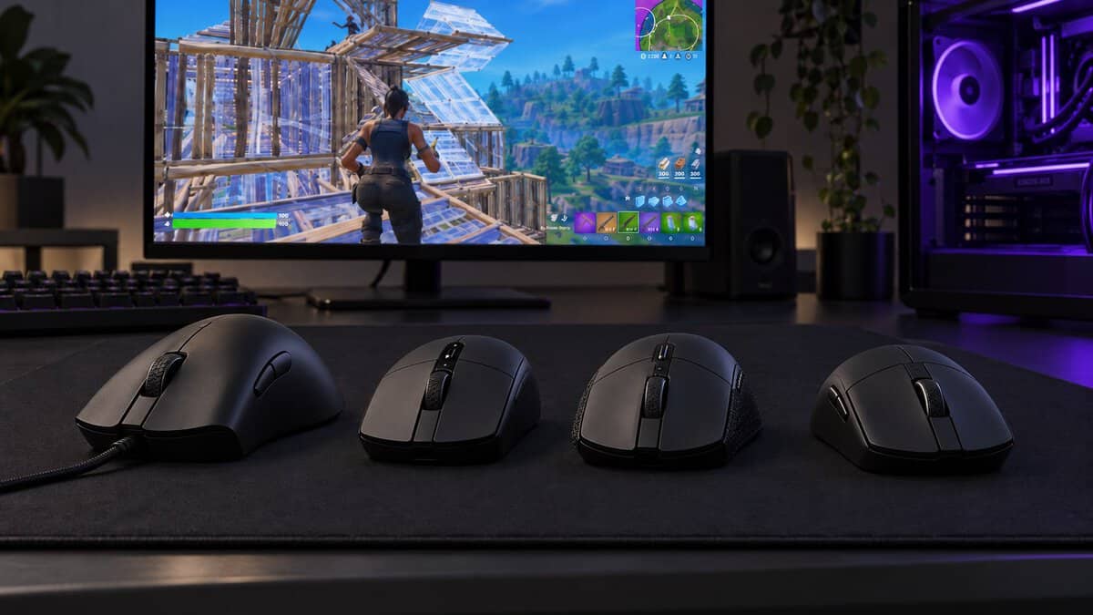 Four black mice in a row for choosing the best mouse for claw grip: a long ergonomic wired mouse, a compact wireless mouse, a low symmetrical mouse with grip tape and a small light symmetrical mouse, with Fortnite on screen