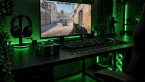 Gifts for PC gamers on a green-lit desk: a black headset on a stand with a glowing base, a wrapped gift box beside the keyboard and Counter-Strike 2 on the monitor