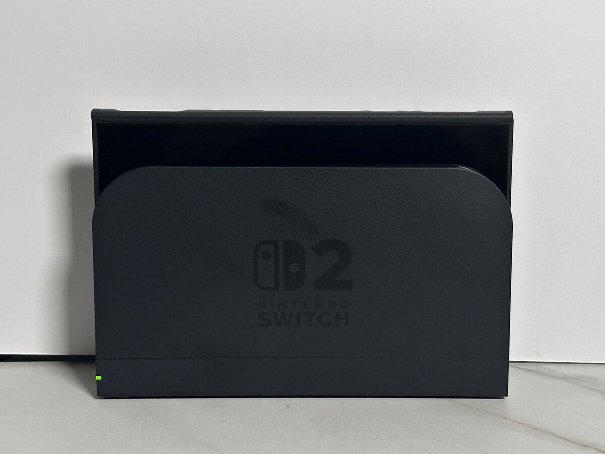 Switch 2 in the JSAUX GoJoy case seated in the official Nintendo dock with its green light on