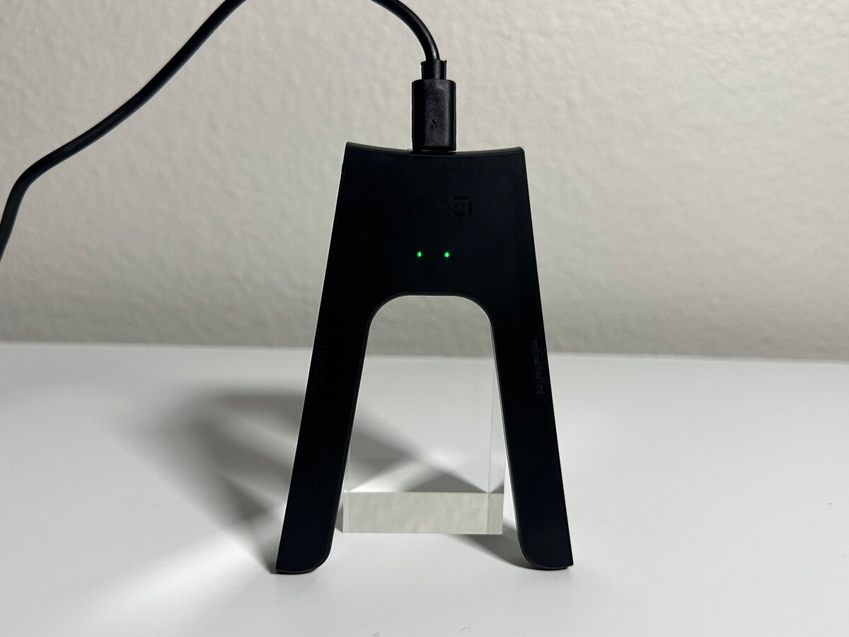 USB-C cable plugged into the top of the JSAUX Switch 2 charging grip with its two charge lights glowing green